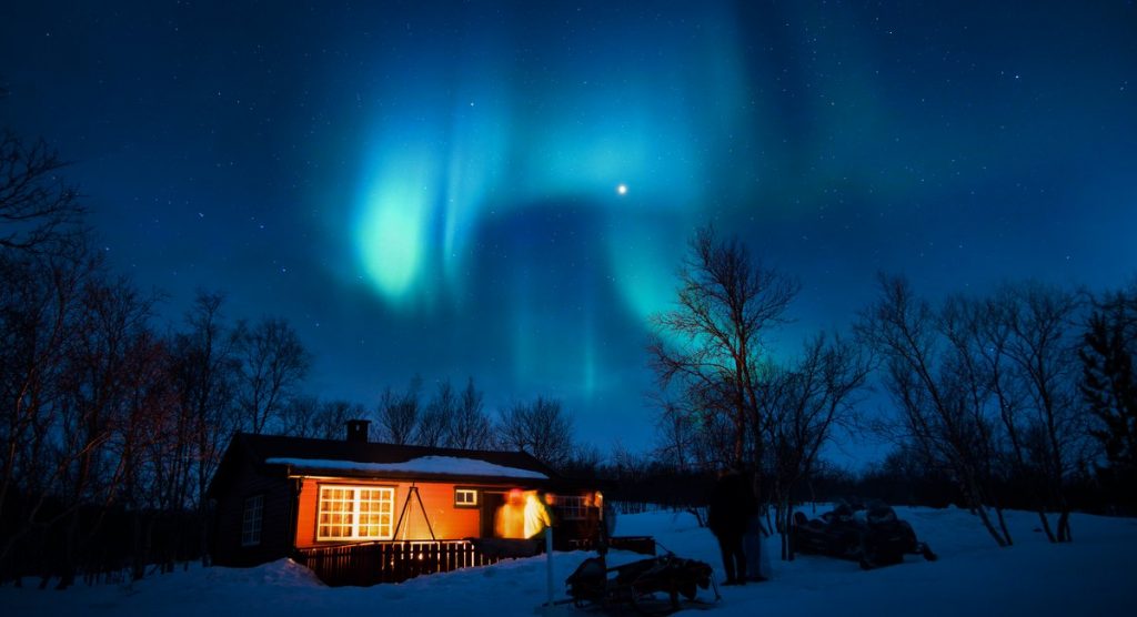 Hytte på fjellet med nordlys
